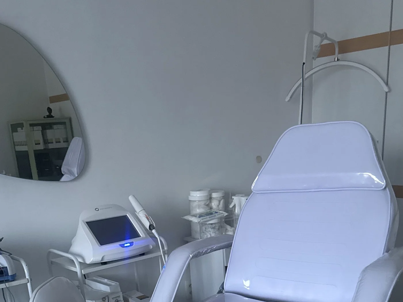 A maca da sala de procedimento e o carrinho com o equipamento de LED