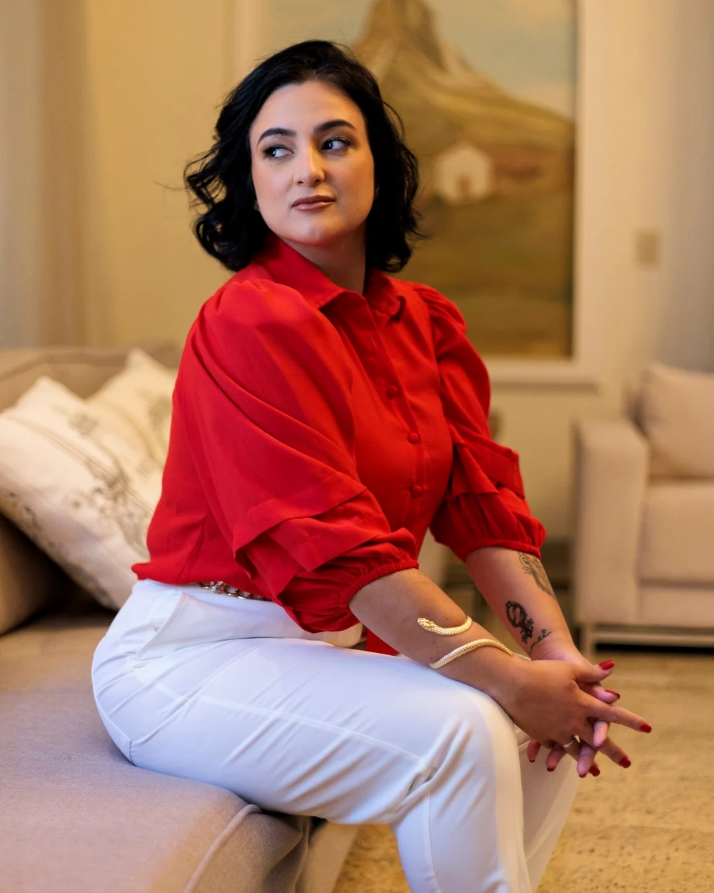 Dra. Luana Cabral sentada em uma sala clara, sorrindo